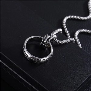 Close-up of silver ring necklace pendant with elvish engraving on a black jewelry box