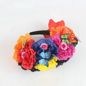 Close-up of vibrant Mexican style headband with colorful fabric roses and butterfly accents