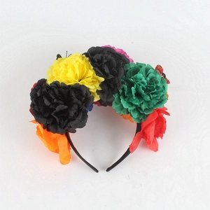 Detail of vibrant faux peony flowers and butterfly decor on a Mexican festive headband