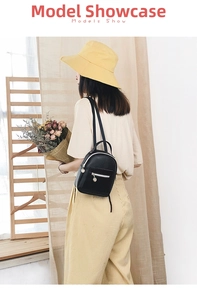 Mini black PU leather backpack for women shown on model with silver zipper details