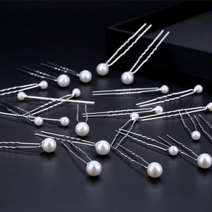 Close-up of white pearls on silver U-shaped hair pins for bridal wedding hairstyles