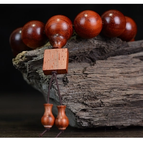 Macro shot of rosewood beads with natural grain on an ancient wooden block background