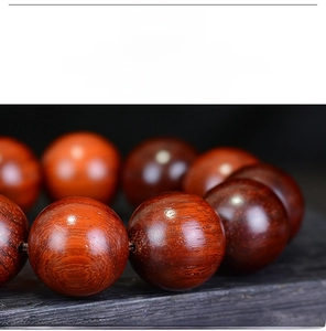 Detailed macro shot of polished Brazilian Rosewood beads with natural oily wood grain
