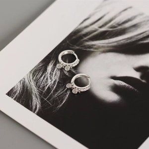 Close-up of S925 sterling silver hoop earrings with sparkling zircon on a portrait photo