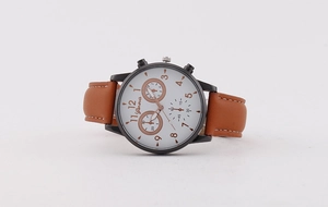 Close-up of Geneva men's quartz watch with brown leather strap and rose gold numerals