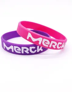 Dettaglio di braccialetti in silicone rosa e viola con logo personalizzato inciso a colori