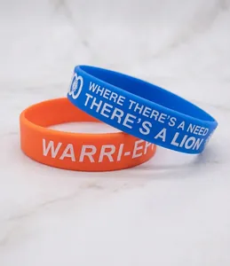 Dettaglio di braccialetti in silicone blu e arancione con slogan stampato in bianco