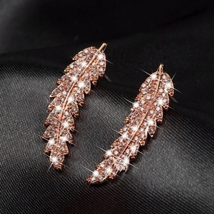 Elegant rose gold leaf earrings with micro-pave cubic zirconia on black silk background