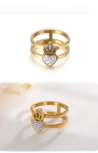 Close-up of golden double-layer ring with sparkling heart and crown crystal details