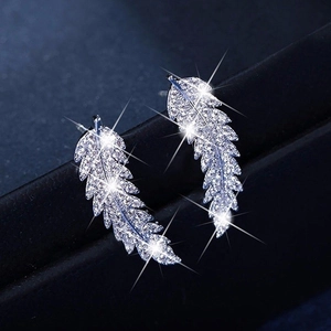 Macro shot of silver leaf earrings with micro-pave white zircon on a dark textured base
