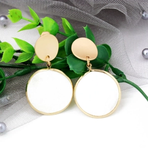 Detailed shot of white round geometric earrings with gold finish on mesh decor