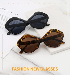 Detailed view of oversized geometric butterfly sunglasses in black and tortoiseshell finishes
