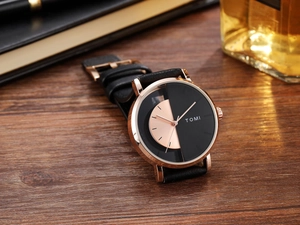 Casual quartz watch with black leather strap on a desk with lifestyle accessories