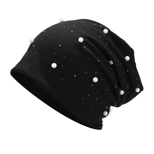 Close-up of black cotton beanie with sparkling rhinestones and white pearl embellishments