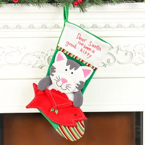 Green Christmas stocking with cartoon cat holding a fish on a fireplace mantel