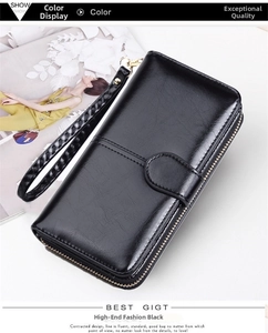 Macro detail of black long zip wallet featuring oil wax leather texture and wristlet