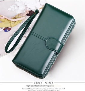 Detail of dark green glossy leather wallet with wristlet and metallic buckle closure