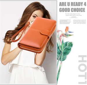 Detail of an orange long wallet with zip-around closure and matching wrist strap for women