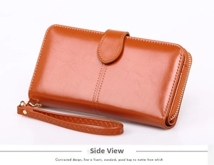 Side view of a long brown oil-wax leather wallet with zipper and braided wristlet strap
