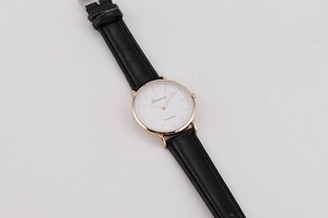 Detail view of ultra-thin quartz watch with black leather strap and rose gold case
