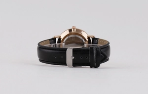 Close-up of black leather strap with rose gold buckle on minimalist quartz watch