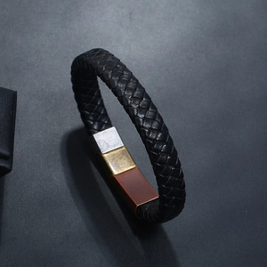 Detail of black braided leather bracelet featuring a unique tri-color magnetic metal clasp