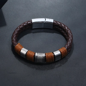 Macro detail of men's brown braided leather bracelet with orange wrap and magnetic clasp