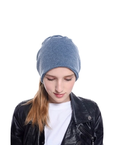 Dettaglio di un berretto in maglia blu da donna con texture morbida e vestibilità ampia