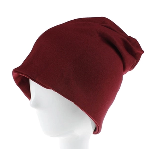 Dettaglio del berretto in maglia bordeaux che mostra la texture morbida e il design