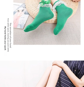 Detail of green Lolita socks featuring delicate white lace trim and sweet bows