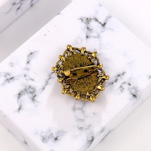 Back view of vintage bronze alloy brooch with intricate floral details and pin clasp