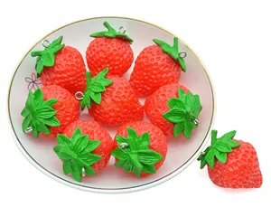 Macro detail of realistic PVC strawberry keychain in a decorative porcelain plate