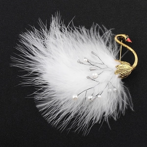 Vintage gold swan brooch featuring white ostrich feathers and faux pearls on black background