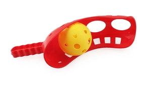 Detail of red launcher handle and yellow perforated ball set for outdoor fun