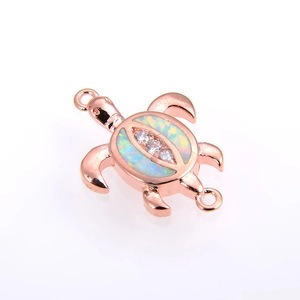 Detail of rose gold sea turtle charm with opal shell and cubic zirconia accents
