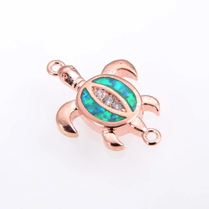 Macro shot of rose gold sea turtle charm with green opal shell and cubic zirconia accents