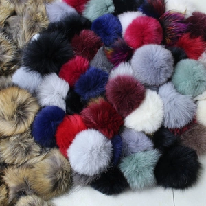 Close-up of fluffy raccoon fur pom poms in multiple colors for hat accessories