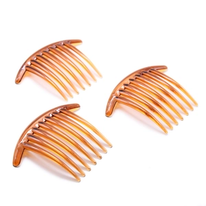 Three amber plastic 7-tooth hair side combs with curved design on white background