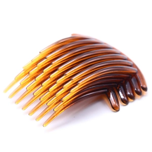 Macro shot of an amber brown 7-tooth plastic hair comb with glossy finish and curved design