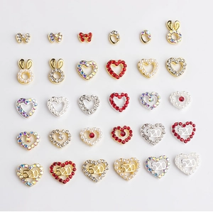 Bowknot and hollow heart nail charms with rhinestones and 520 design on white background