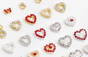Macro shot of 520 hollow heart and bow-knot nail art charms with pearls and rhinestones
