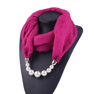 Close-up of rose red chiffon scarf necklace with white pearls and gold hardware