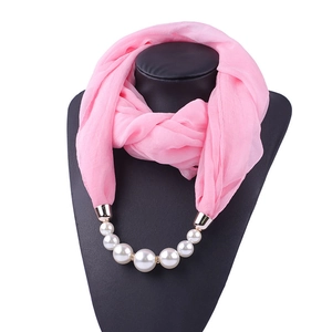 Detailed view of pink chiffon scarf necklace with pearls and gold beads on a mannequin