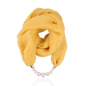 Detail view of yellow chiffon scarf necklace with gradient pearl pendant and metal clasp