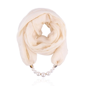Detailed close-up of beige chiffon scarf featuring elegant pearl and metal pendant charms