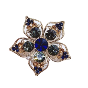 Vintage floral brooch with deep blue center stone and champagne crystals on gold alloy