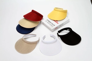 Detail view of woven sun visor hats in seven assorted colors arranged in a semi-circle