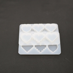 Macro detail of translucent pixel and smooth heart-shaped silicone molds for DIY resin crafts