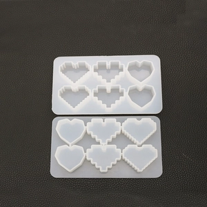 Macro shot of two heart-shaped silicone molds featuring pixelated and smooth designs