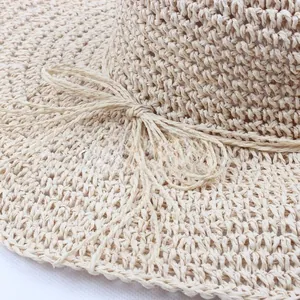 Close-up of beige woven straw hat detailing a breathable mesh pattern and ribbon bow